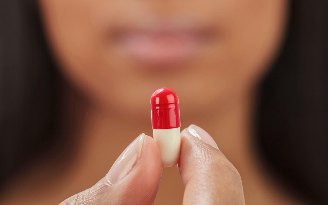Close up of mixed race woman holding medication capsule